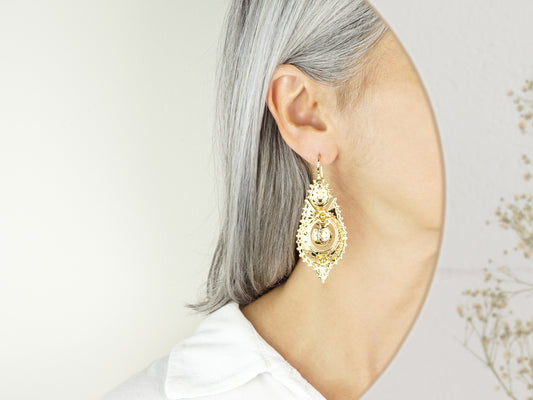 Brincos Rainha "Casca d'Ovo" Grandes, Inspirados na Filigrana Portuguesa, Aço Inoxidável Dourado - Pormenor Mulher a usar Brinco