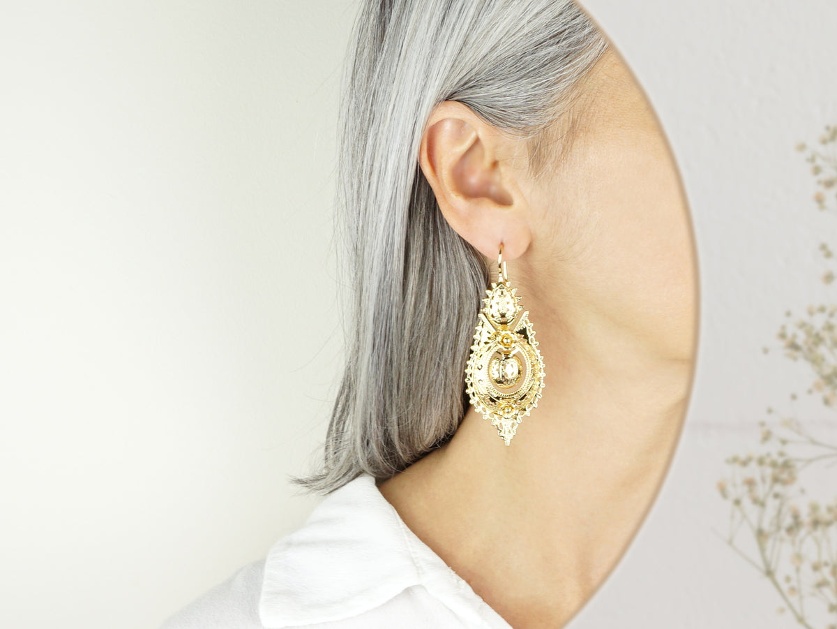 Brincos Rainha "Casca d'Ovo" Grandes, Inspirados na Filigrana Portuguesa, Aço Inoxidável Dourado - Pormenor Mulher a usar Brinco